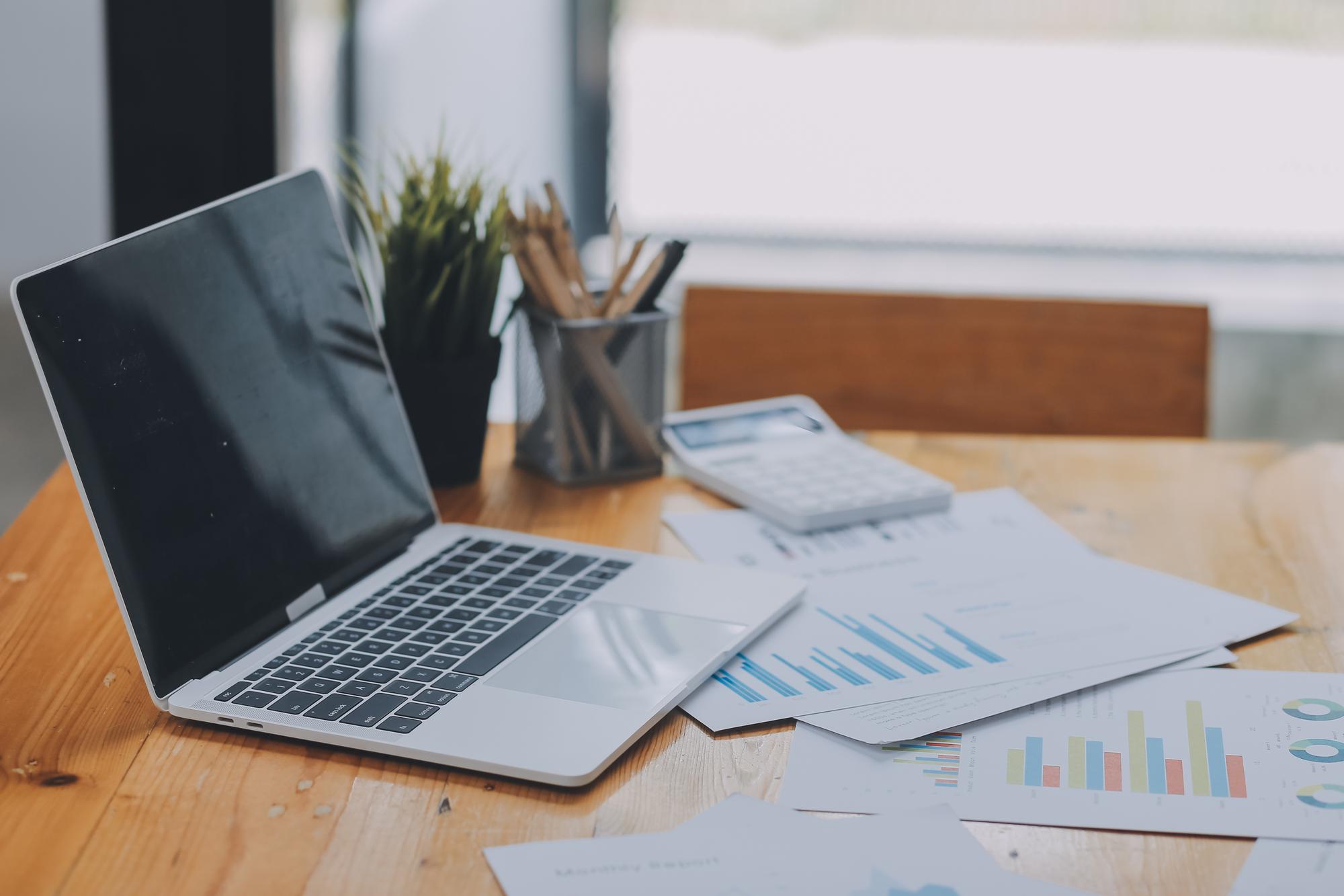 Office workspace with financial reports and laptop